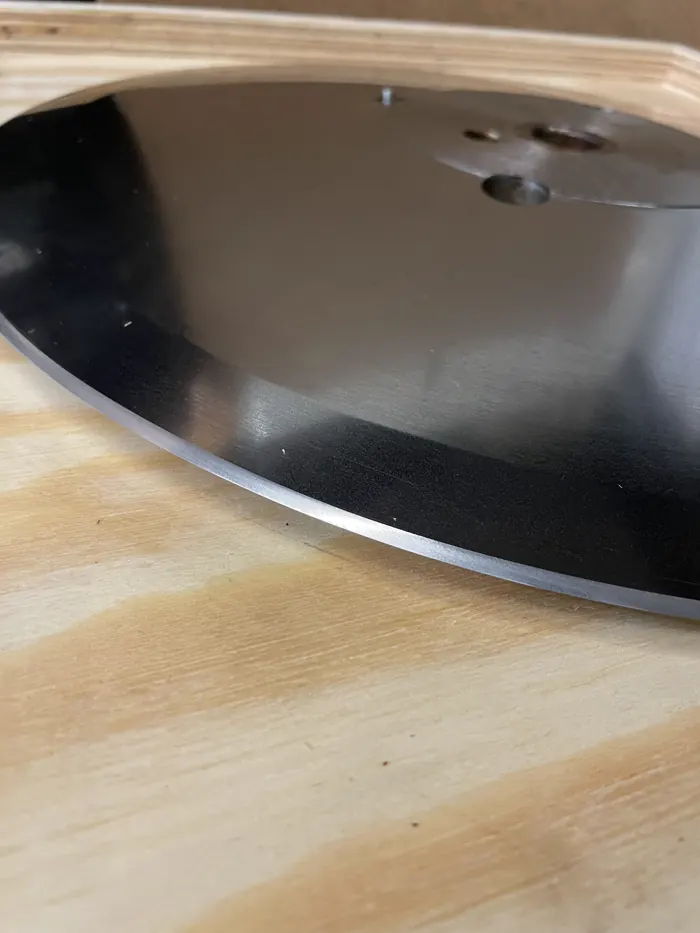 Lame circulaire de trancheuse après affûtage, posée sur un établi